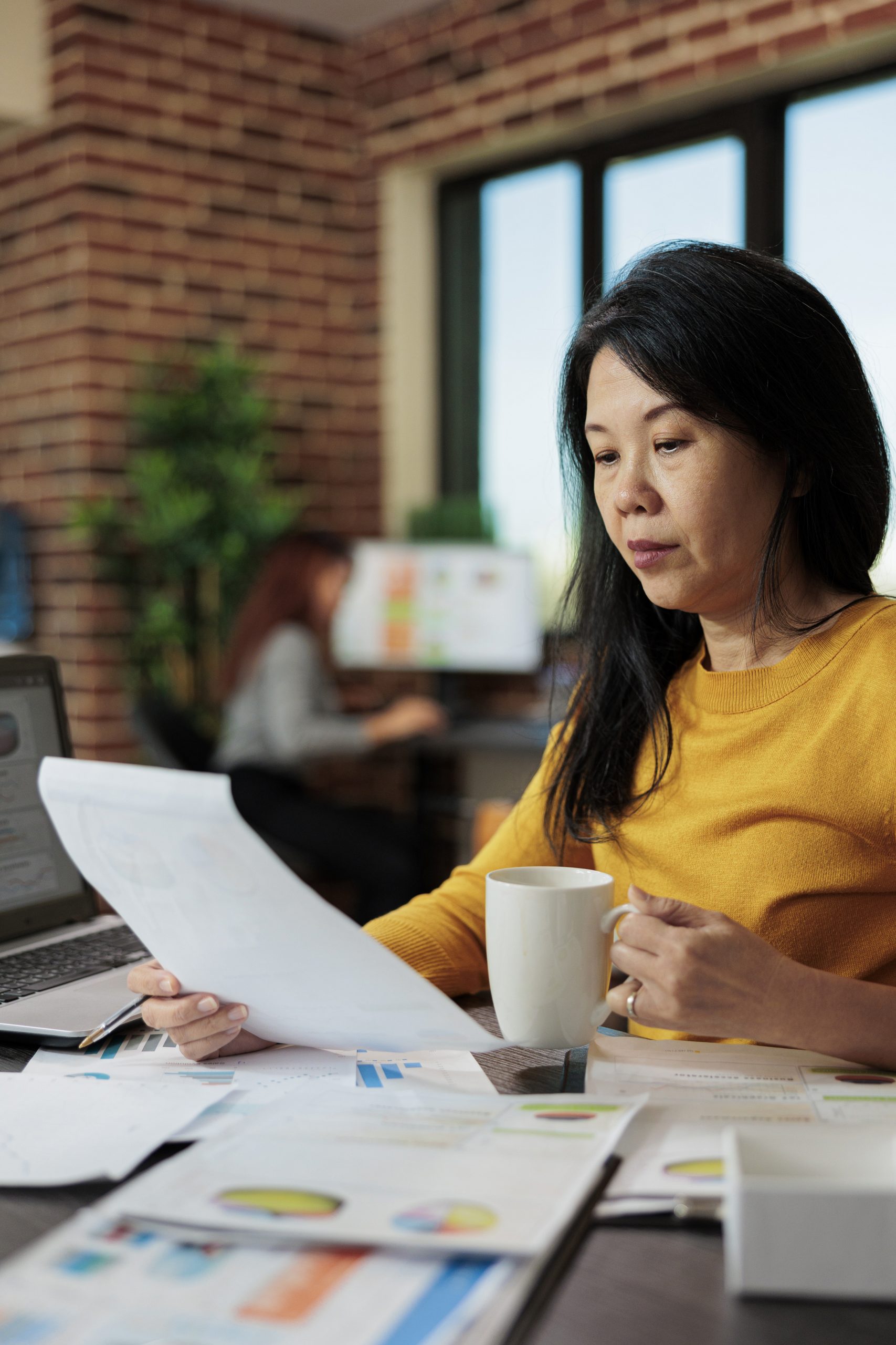 Professional woman reviewing financial report, highlighting informed wealth management and investment planning.